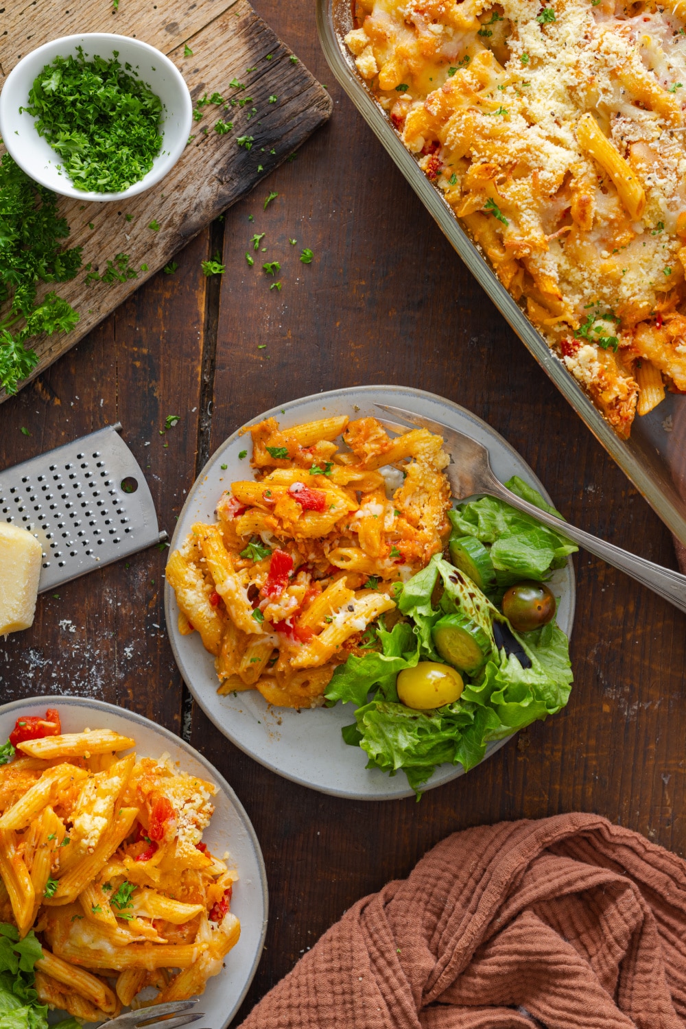 Chicken Parmesan Casserole on a white plate with a salad.
