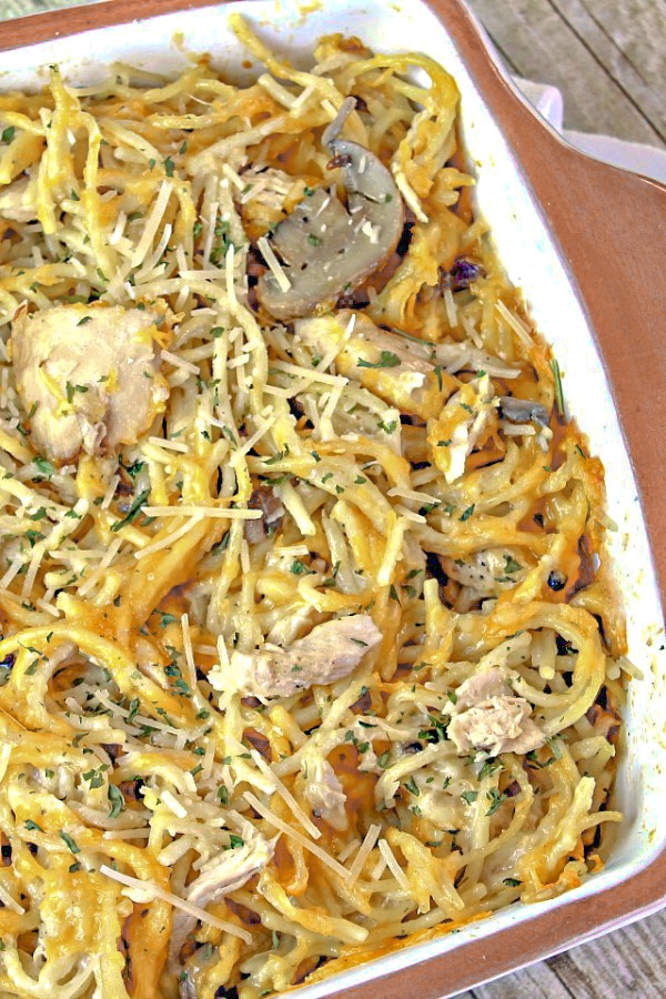 Fully cooked chicken tetrazzini in a casserole dish on wooden background. 