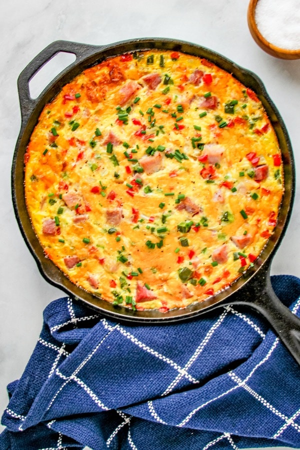 Western Omelette Frittata baked in a cast iron skillet garnished with chives