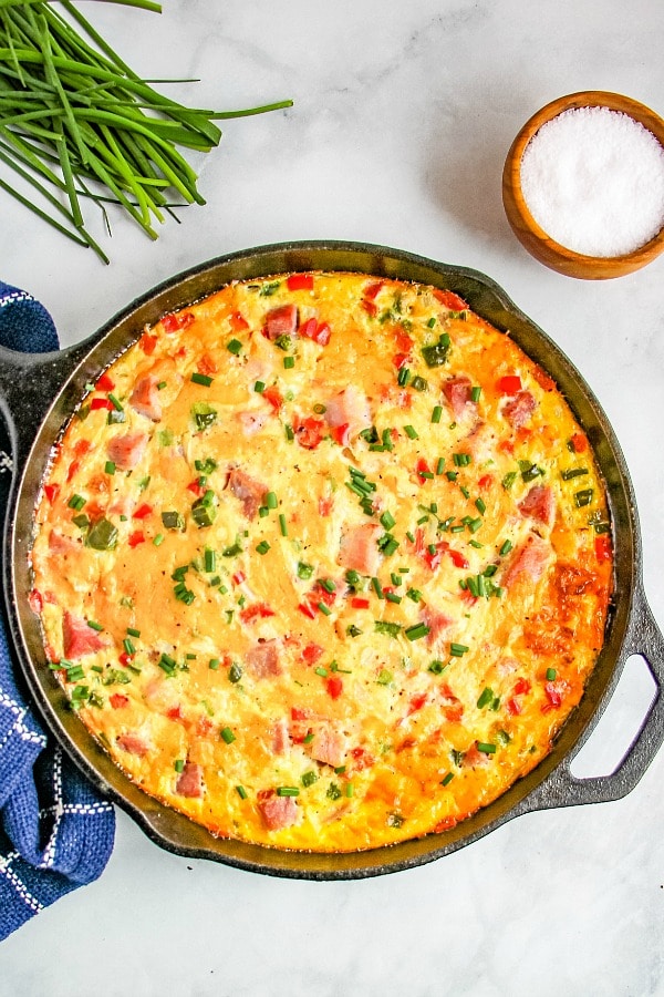 Western Omelette Frittata baked in a cast iron skillet garnished with chives