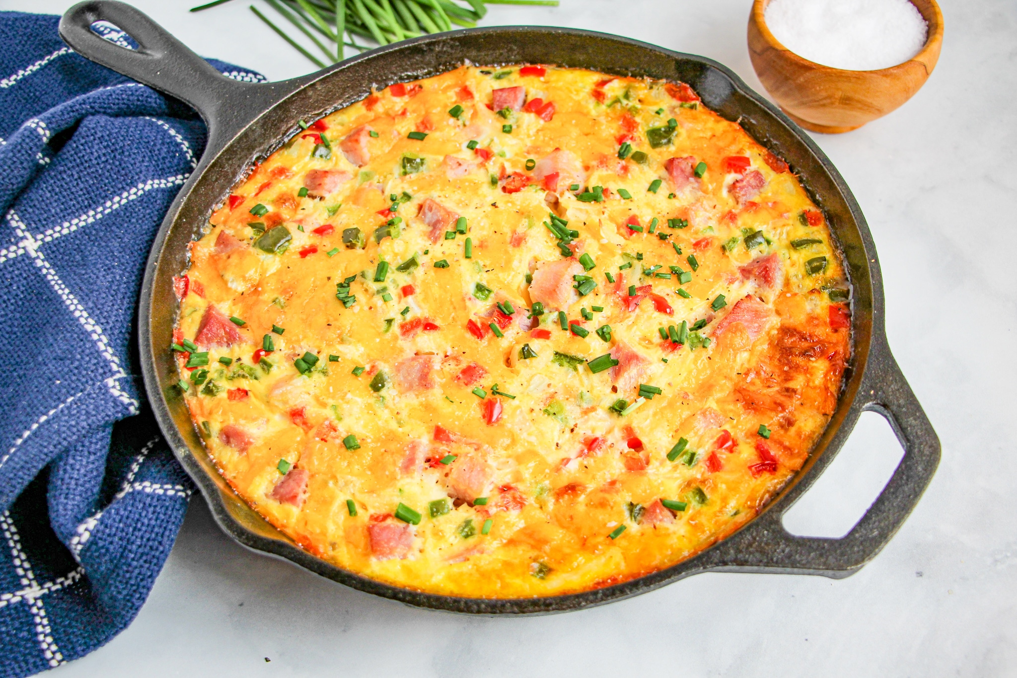 Western Omelette Frittata baked in a cast iron skillet garnished with chives