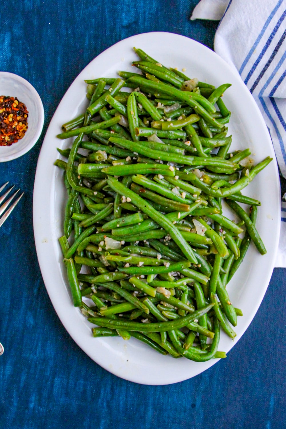 Skillet Green Beans on a white platter on blue background 