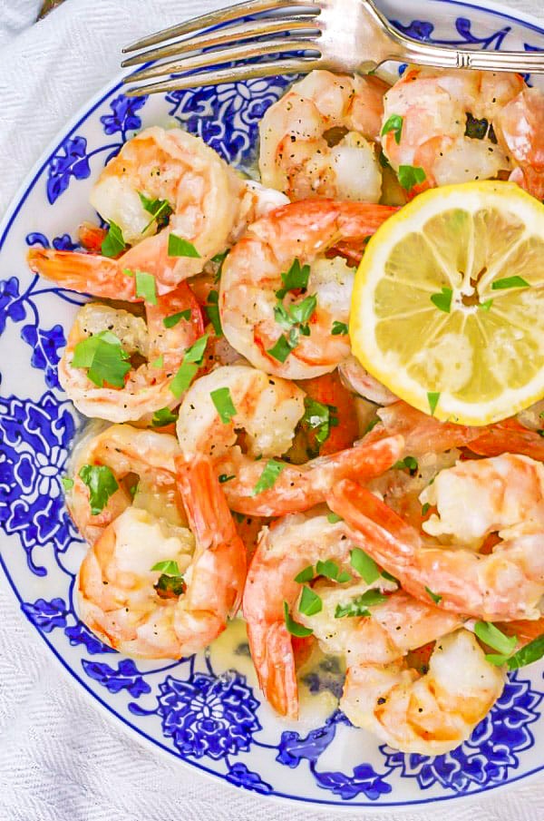 Garlic Butter Shrimp on a blue and white plate with a slice of lemon