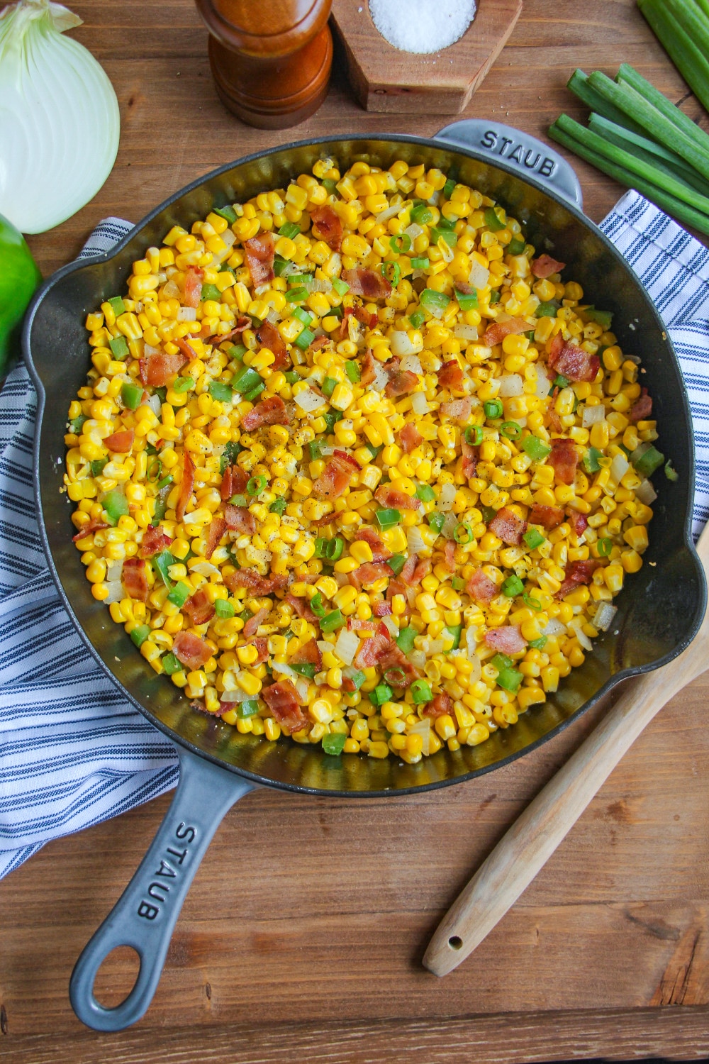 A cast iron skillet filed with Southern Fried Corn and garnished with scallions.