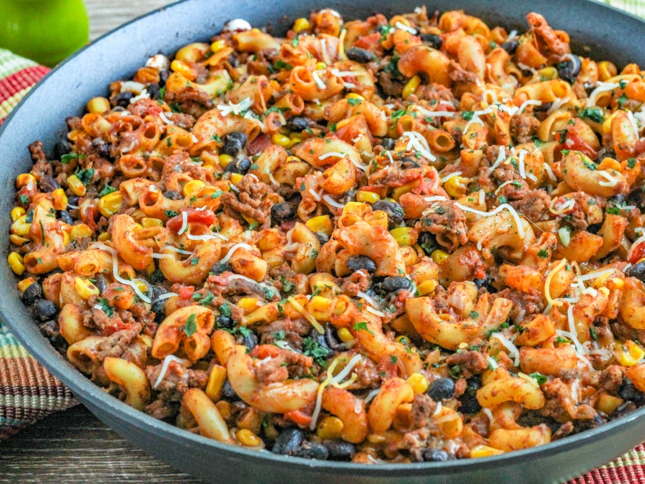 Taco Mac 'n Cheese in a skillet with striped dish towel 