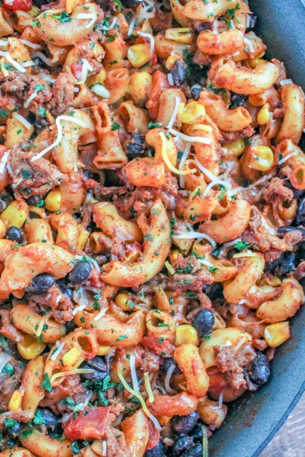 Taco Mac 'n Cheese garnished with shredded cheese in a non-stick skillet 