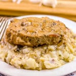 Slow Cooker Smothered Pork Chops on a bed of mashed potatoes