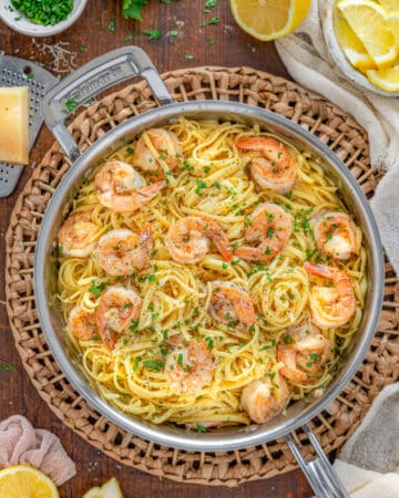 Lemon Garlic Parmesan Shrimp Pasta in a skillet garnished with cracked pepper and parsely.