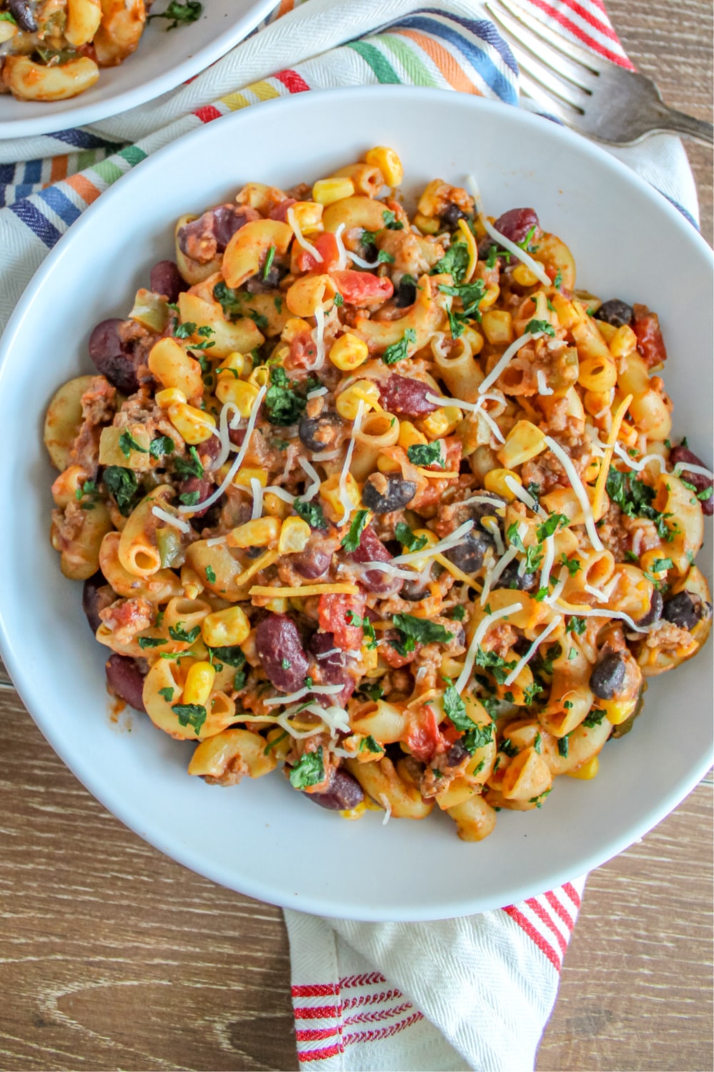 Instant Pot Taco Pasta in white bowl garnished with cilantro and shredded cheese. 