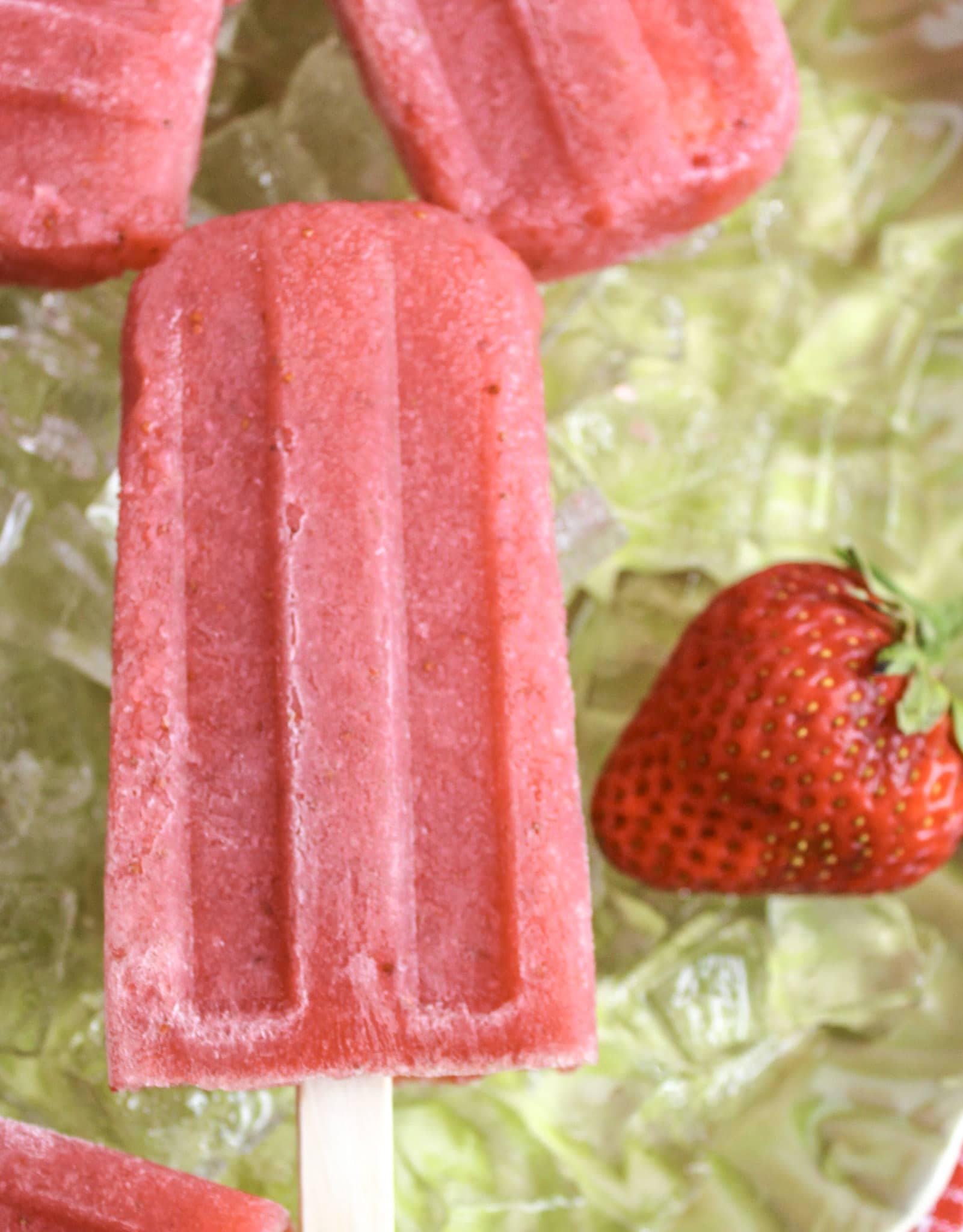 Strawberry Daiquiri Popsicles on a bed of ice with strawberry 