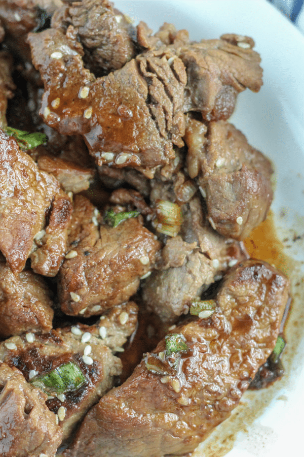 Teriyaki Steak Bites garnished with sesame seeds on white platter