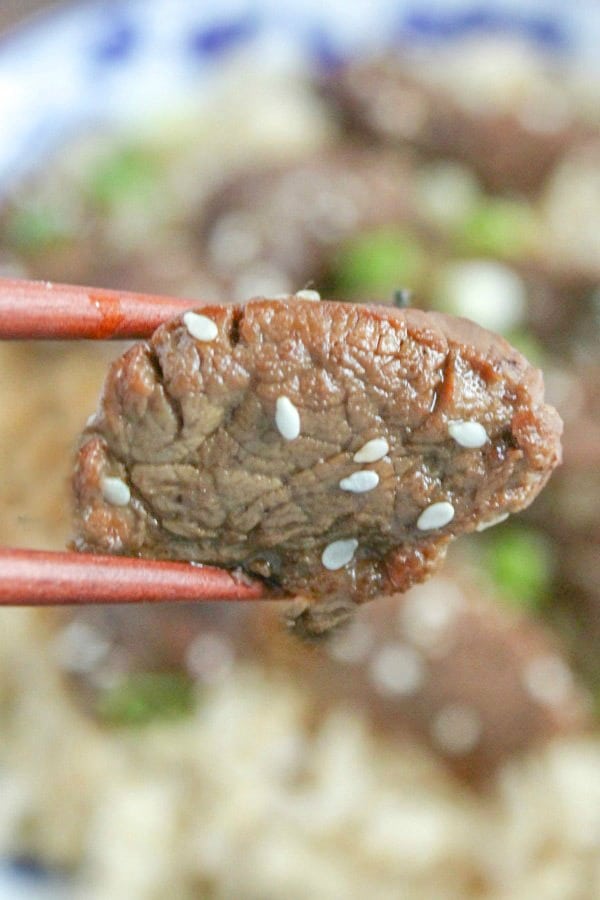 Teriyaki Steak Bite being held between chop sticks 