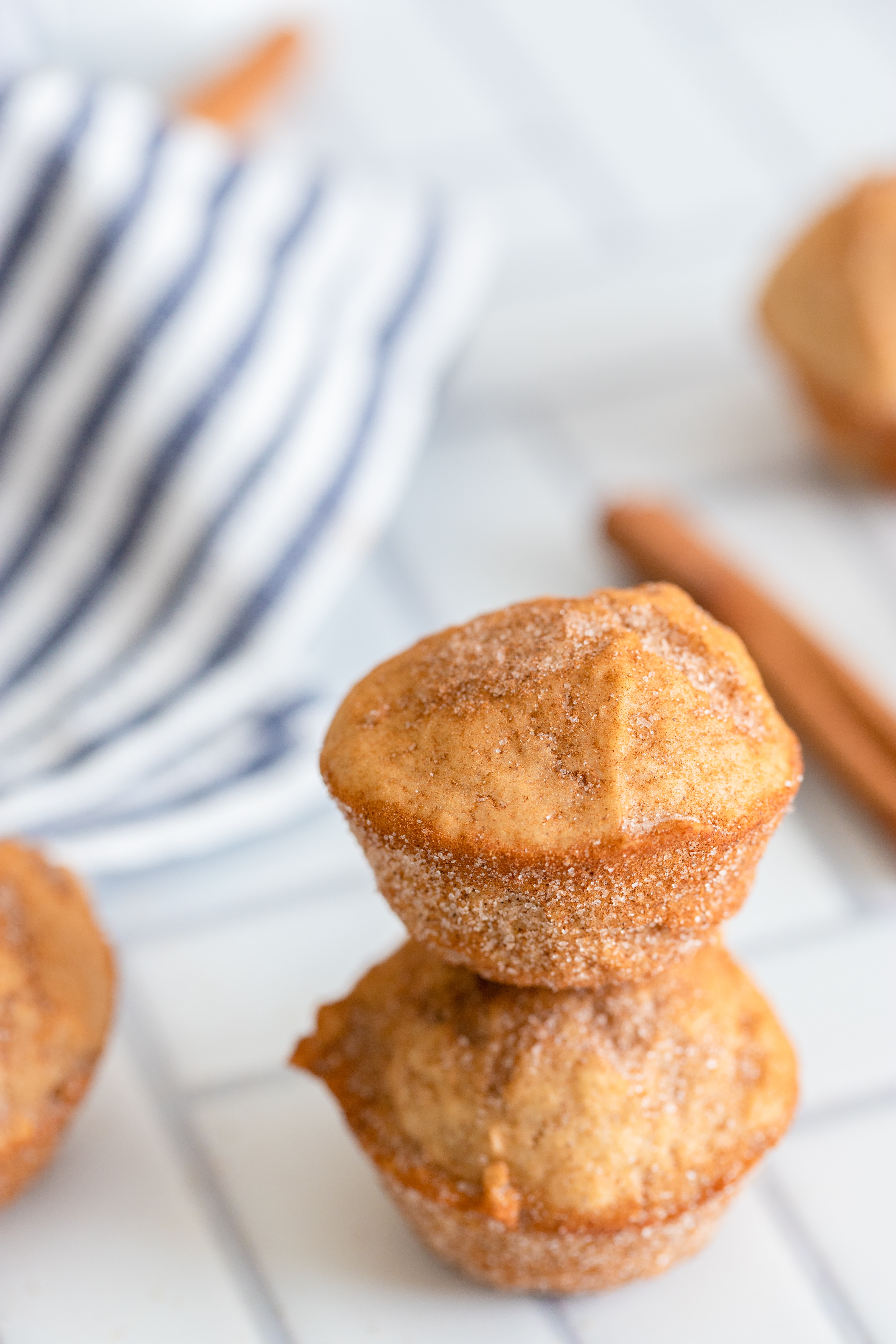 Cinnamon Sugar Mini Muffins on a white tile background.