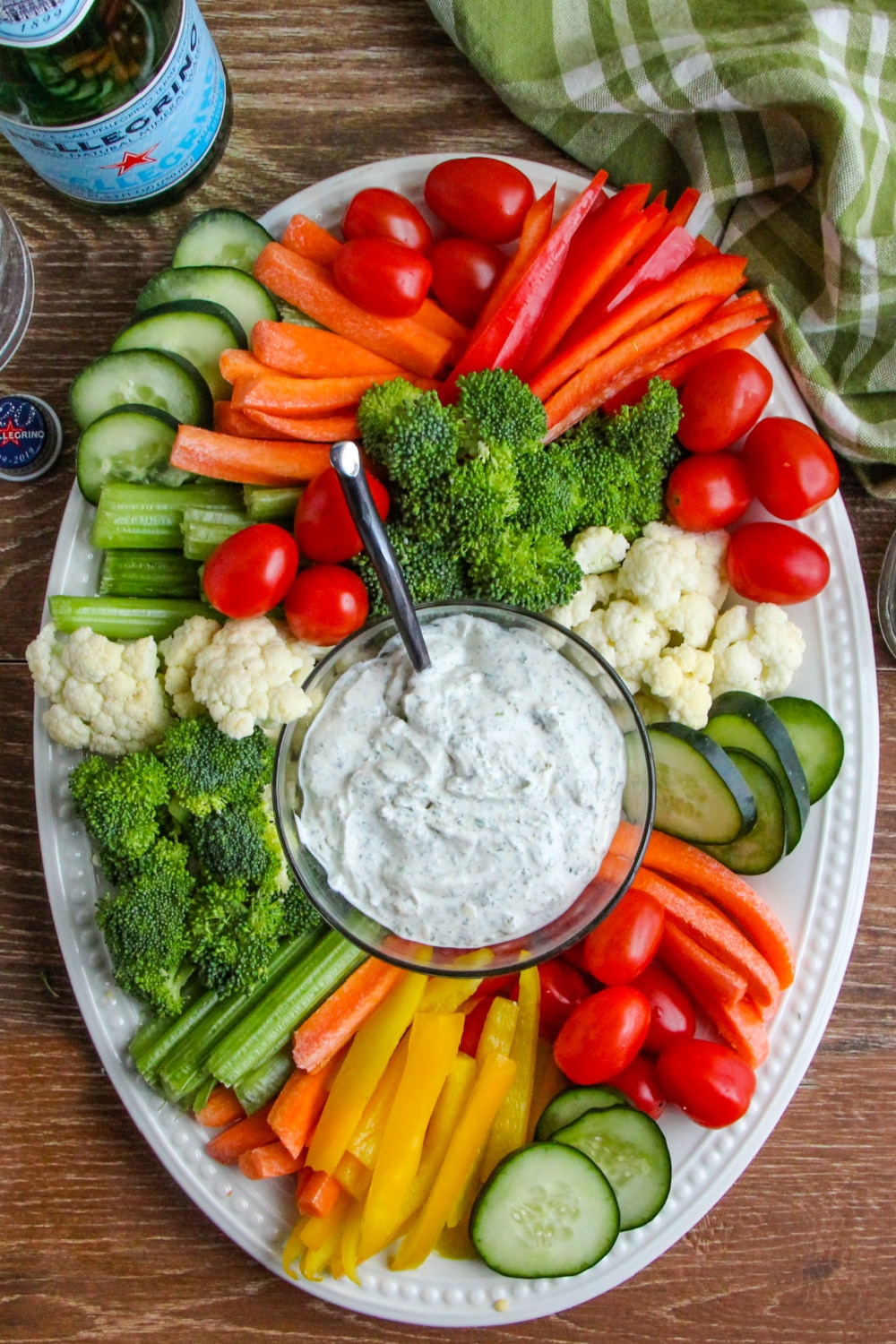 A tray of vegetables with ranch dip.