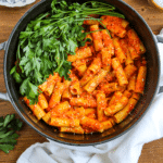 Roasted Red Pepper Pasta in a stock pot on a wood back ground.