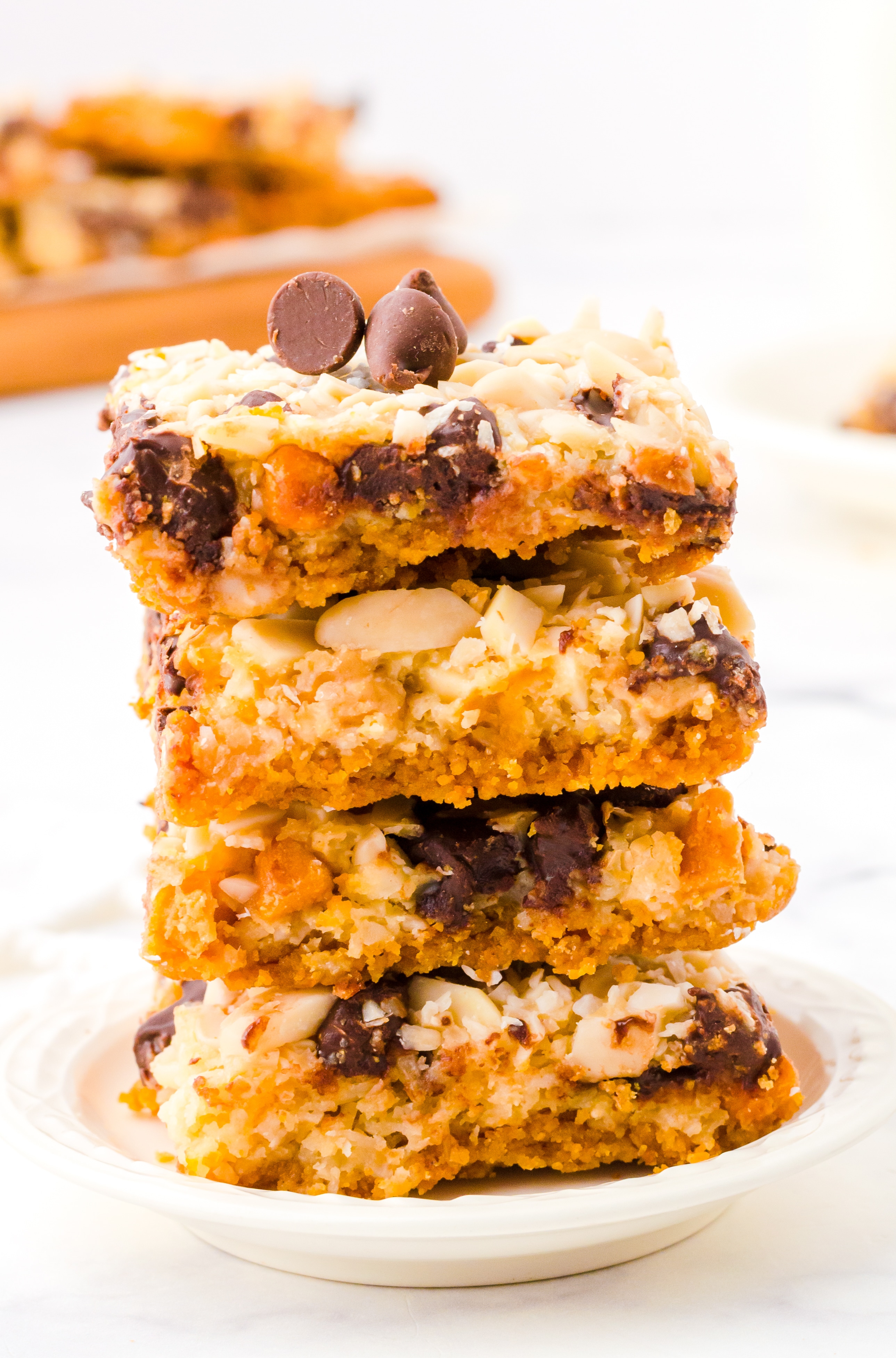 Three Hello Dolly Bars stacked on top of each other on a white saucer.