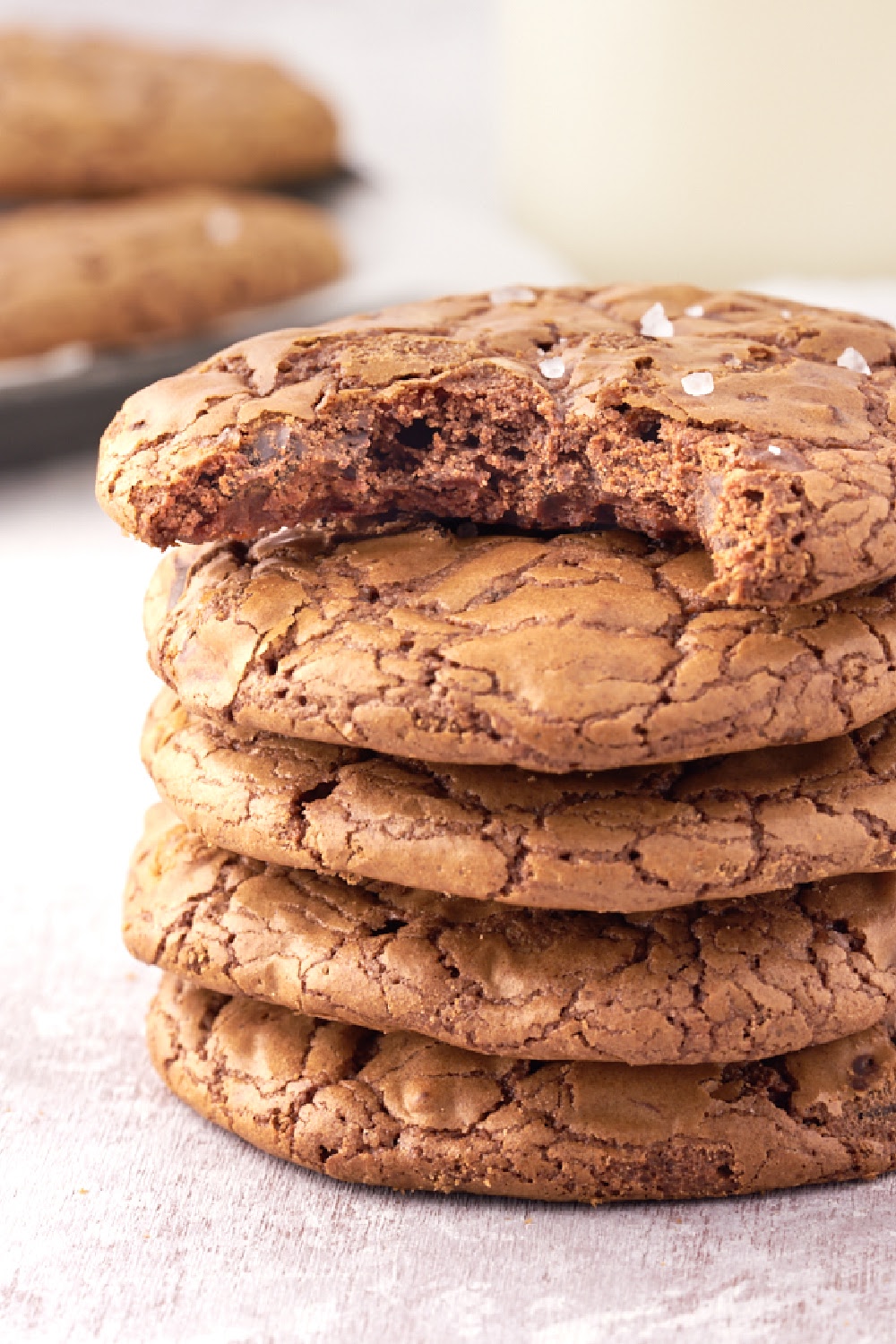 Brownie Cookies in a stack with the top cookie missing a bite to show the gooey inside.