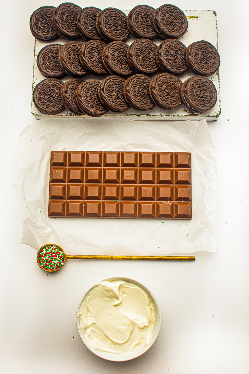 Ingredients needed to make Oreo Truffles laid out in measured amounts on white parchment paper. 