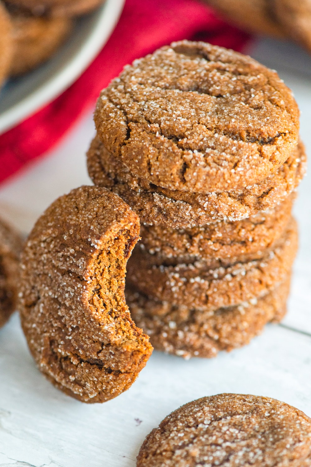 A stack of gingersnap cookies next to a red dish towel. 