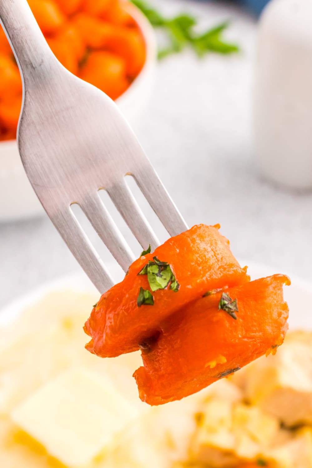Two prepared carrot slices pierced on a fork.