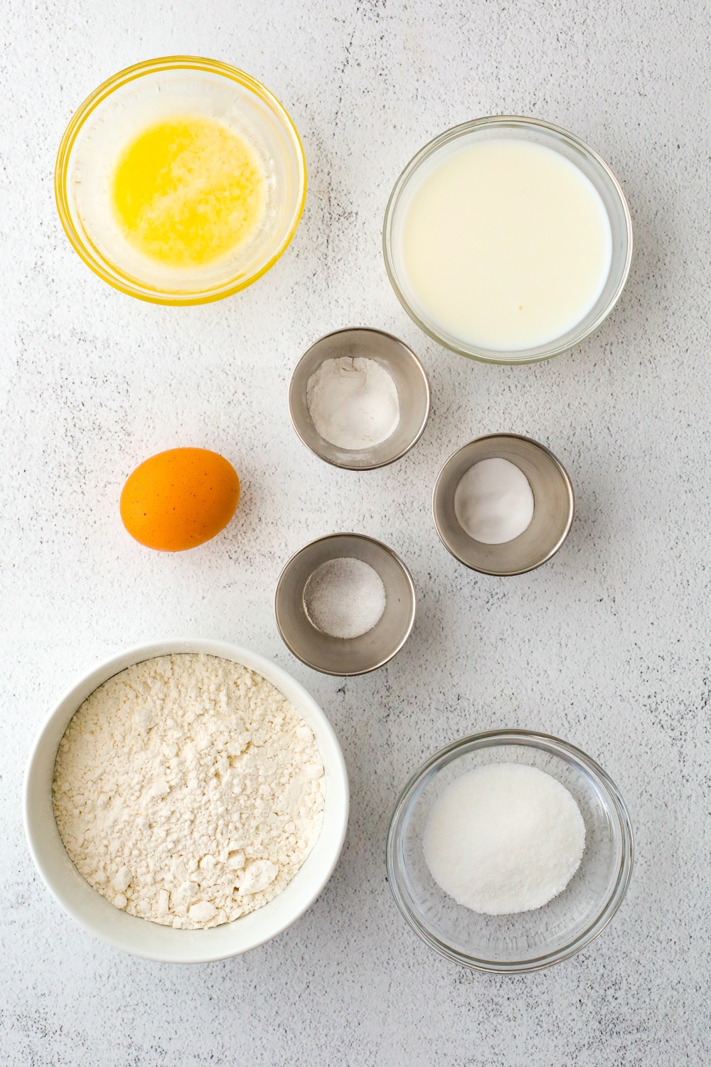 Measured ingredients in bowls needed to make pancakes.