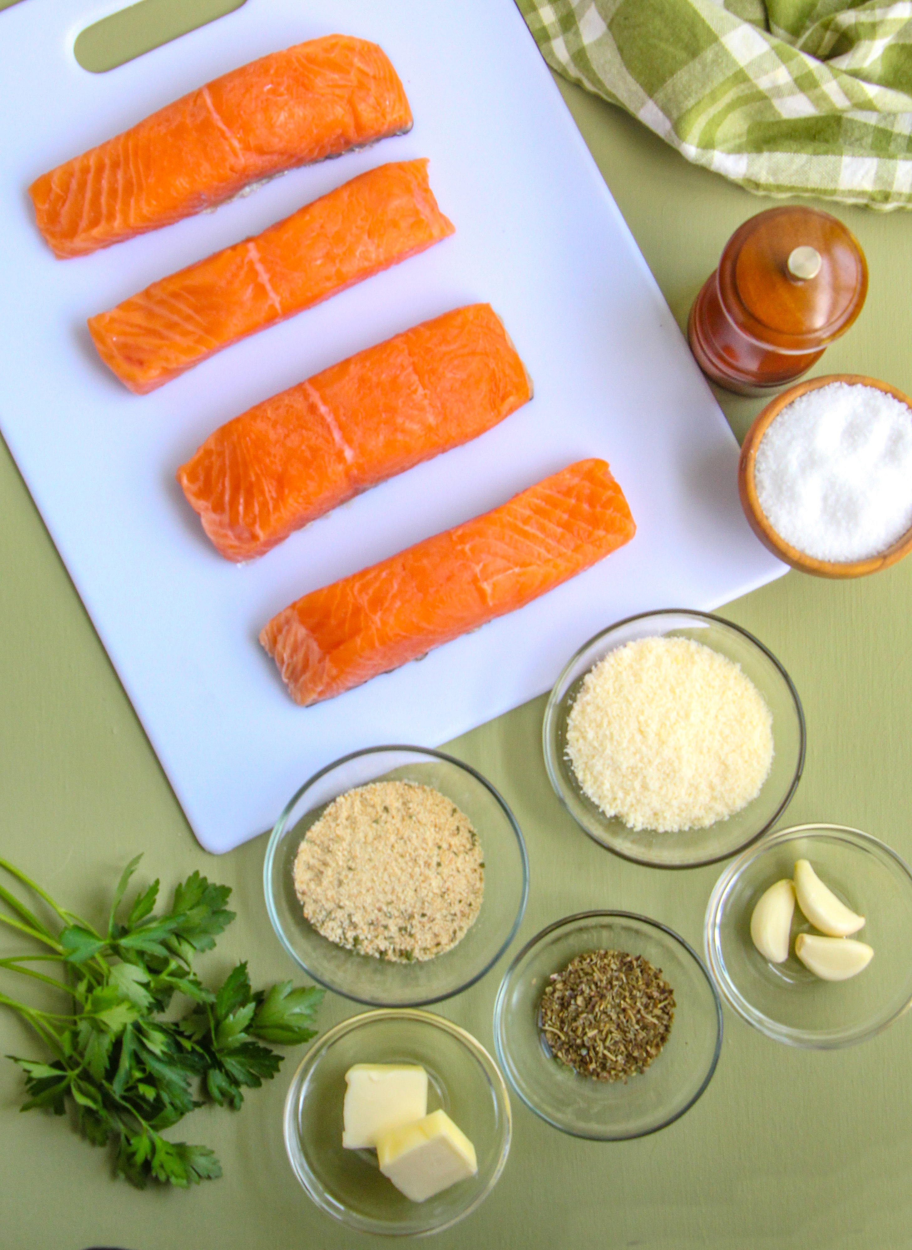 Four salmon fillets with measured ingredients to make this recipe presented in glass bowls.