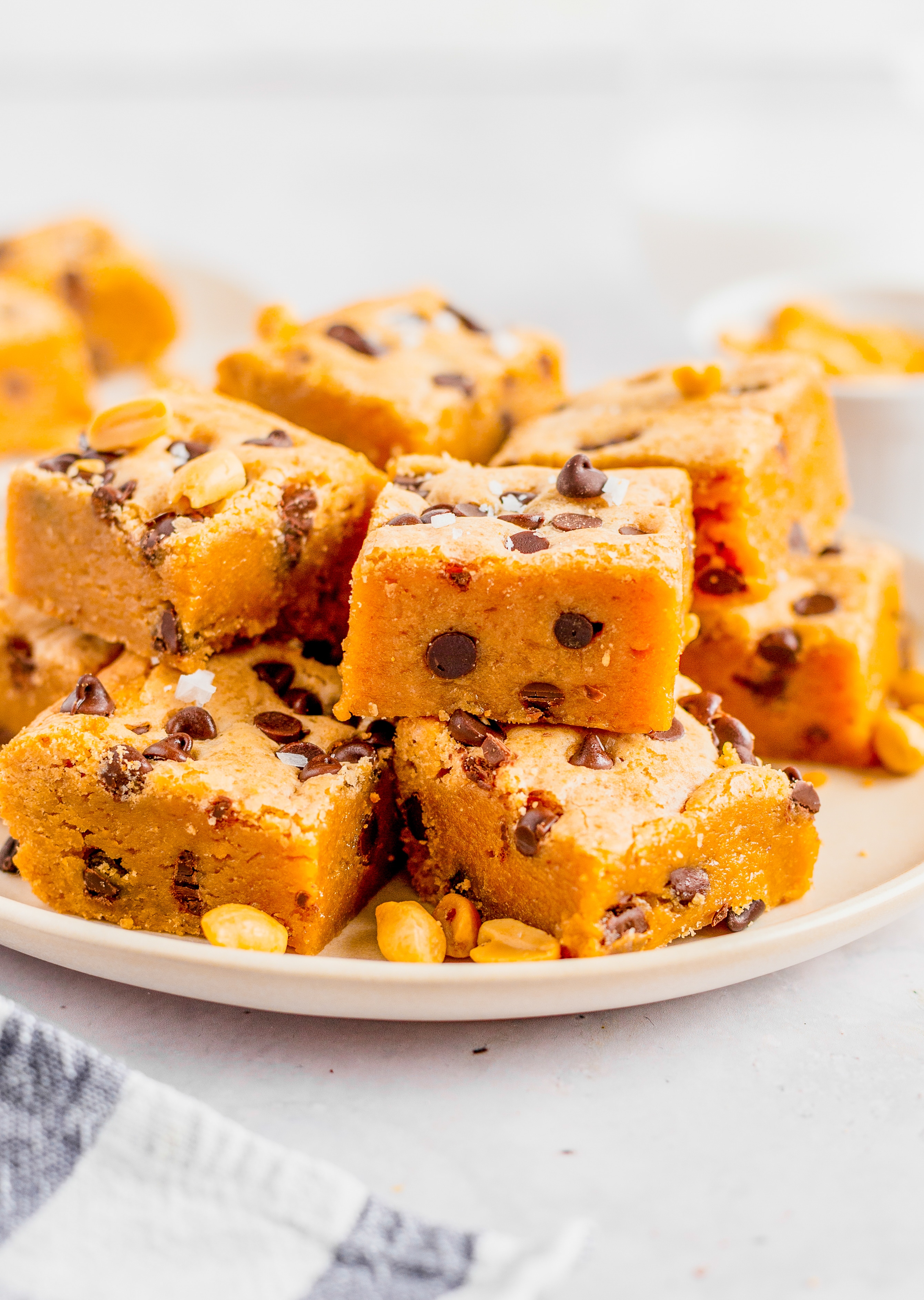 A white plate with a pile of Peanut Butter Chocolate Chip Blondies.