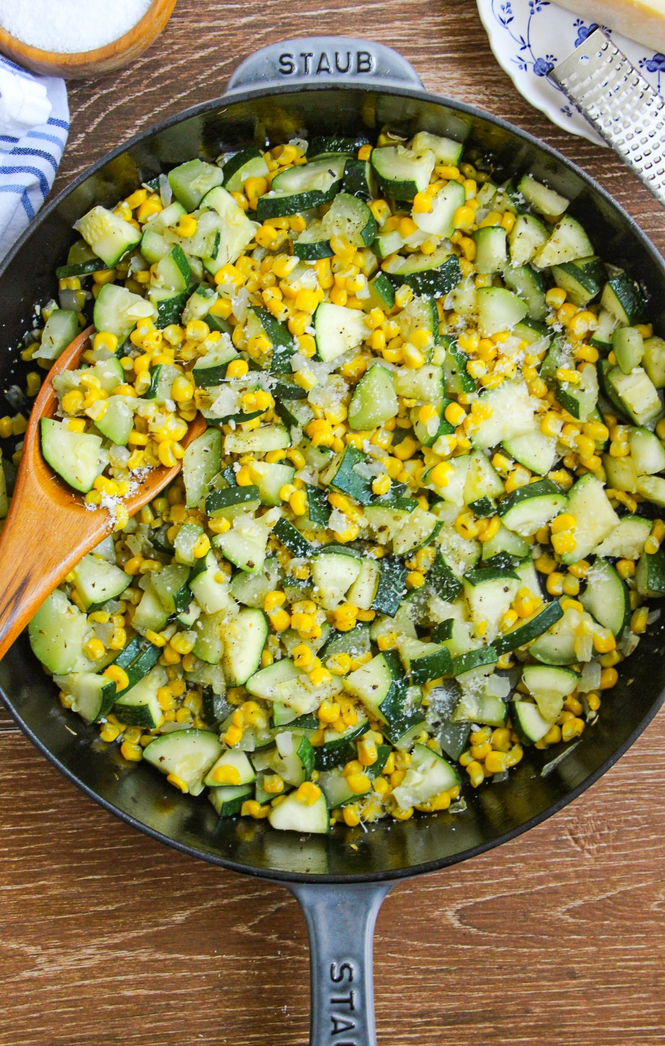 Sautéed Corn and Zucchini in a large skillet with a wooden spoon.