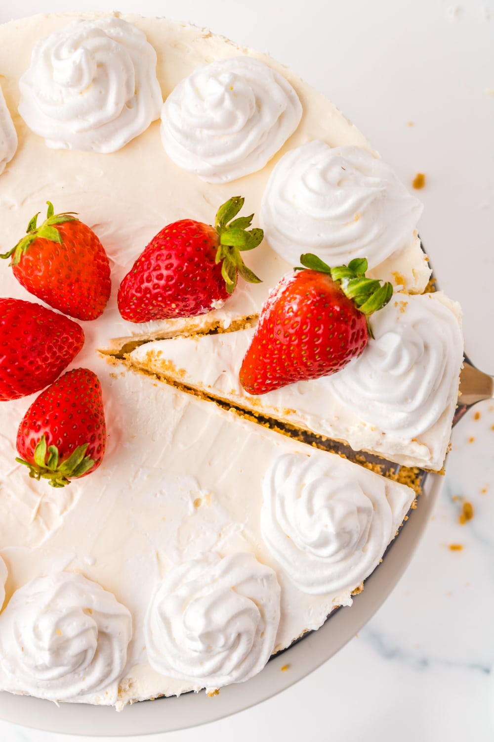 No Bake Cheesecake topped with strawberries and whipped cream.