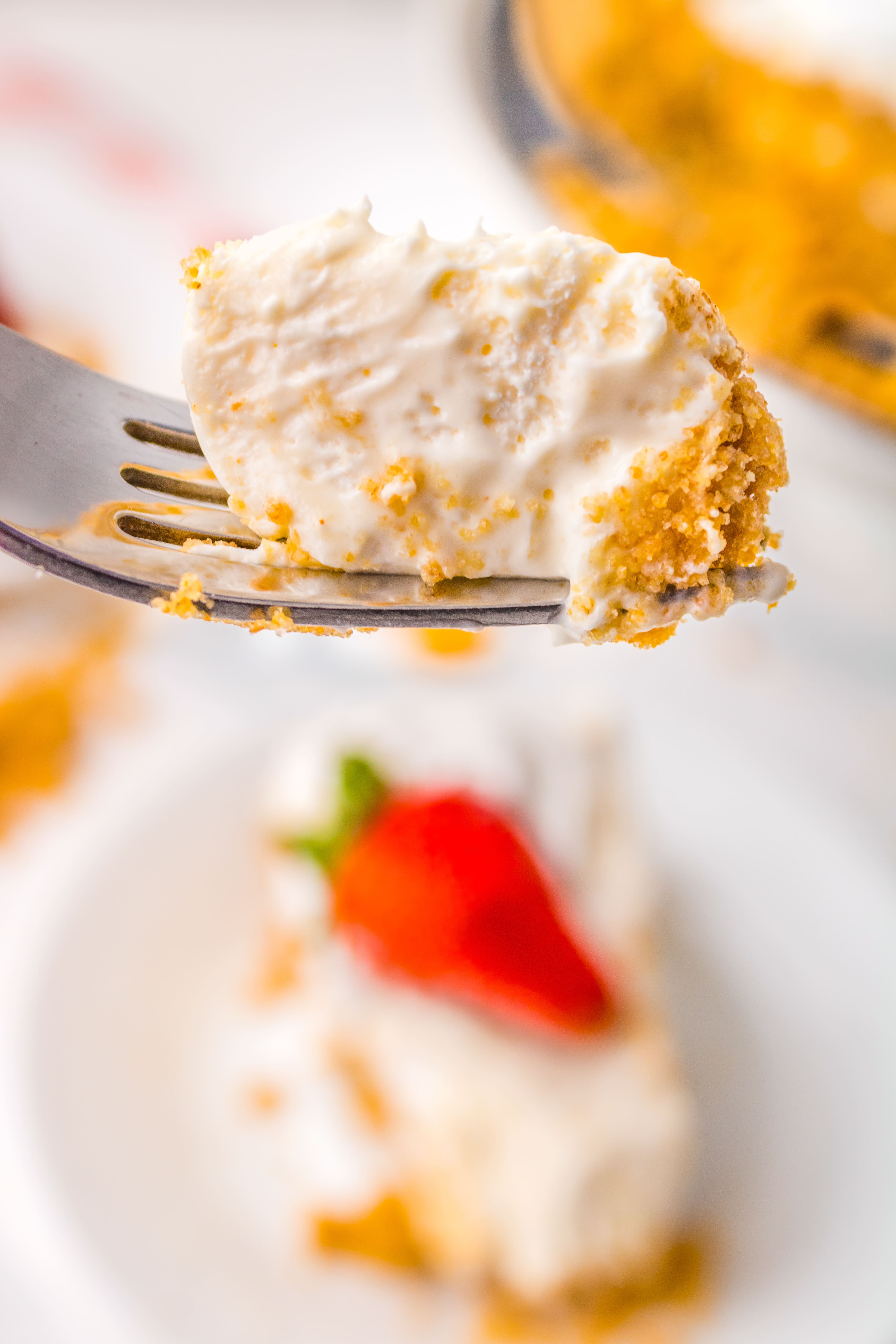 A bite of creamy cheesecake on a fork.