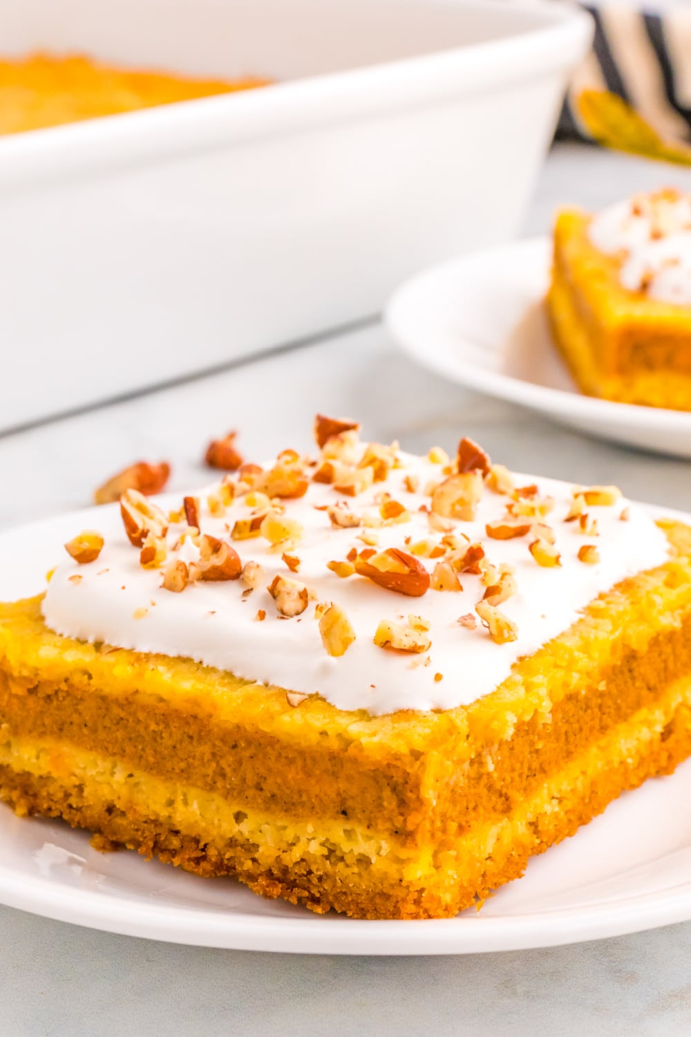 A single slice of Pumpkin Pie Cake sits on a white dessert plate.