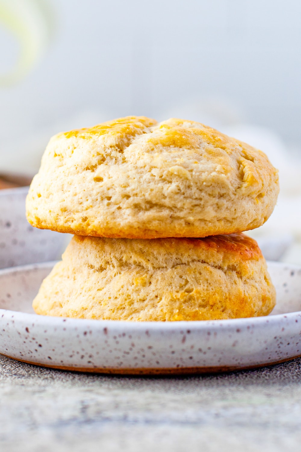 Two Buttermilk Biscuits stacked together on a white plate.