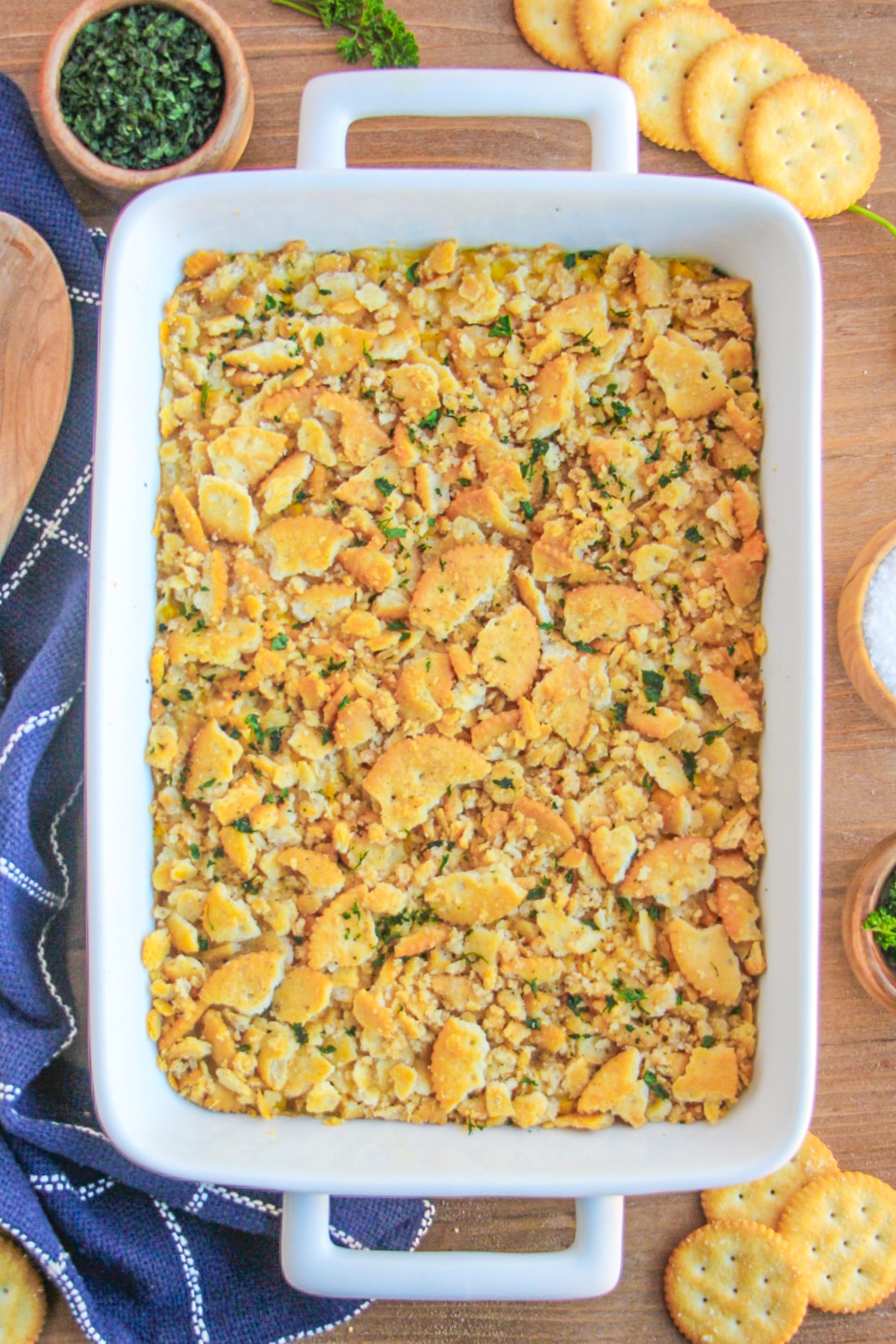 Corn Casserole in a white baking dish garnished with chopped parsley.