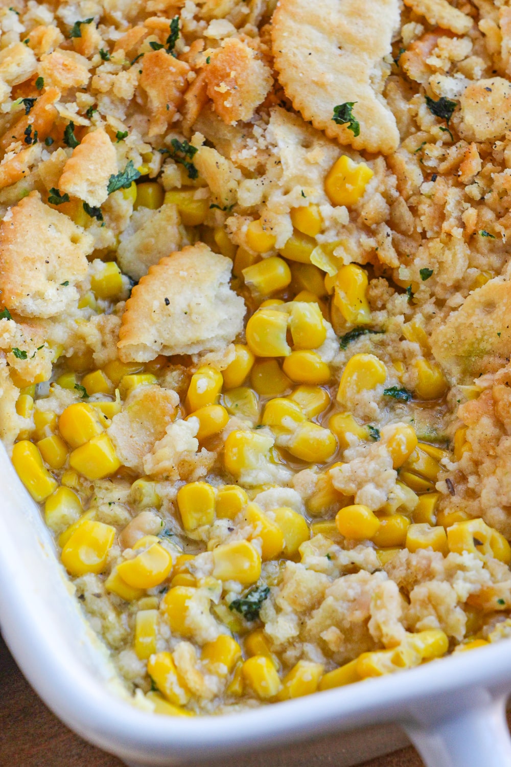 Corn Casserole partially scooped away in the baking dish exposing the center of the casserole.