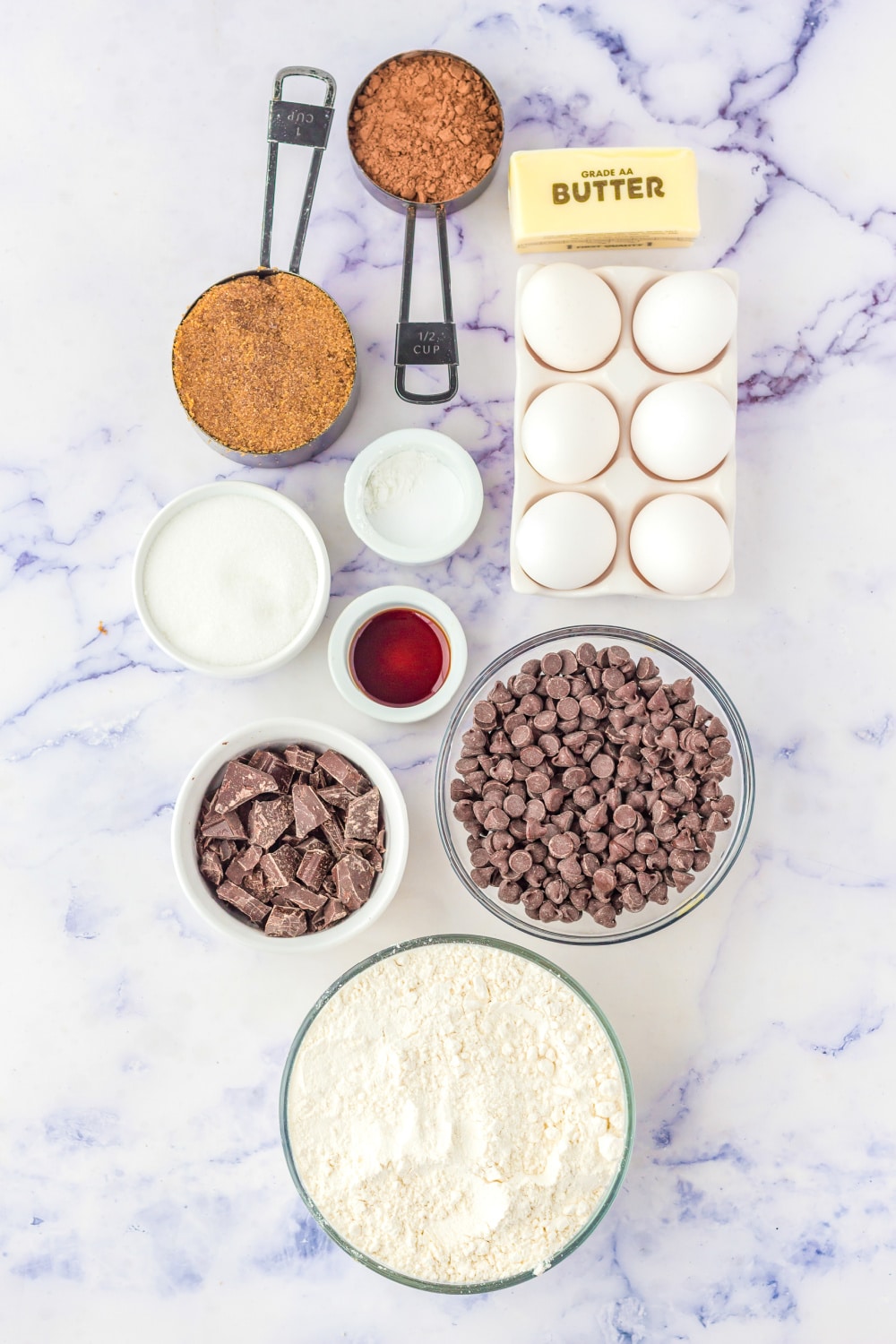 Measured Ingredients needed to make these cookies presented on a white marble countertop.