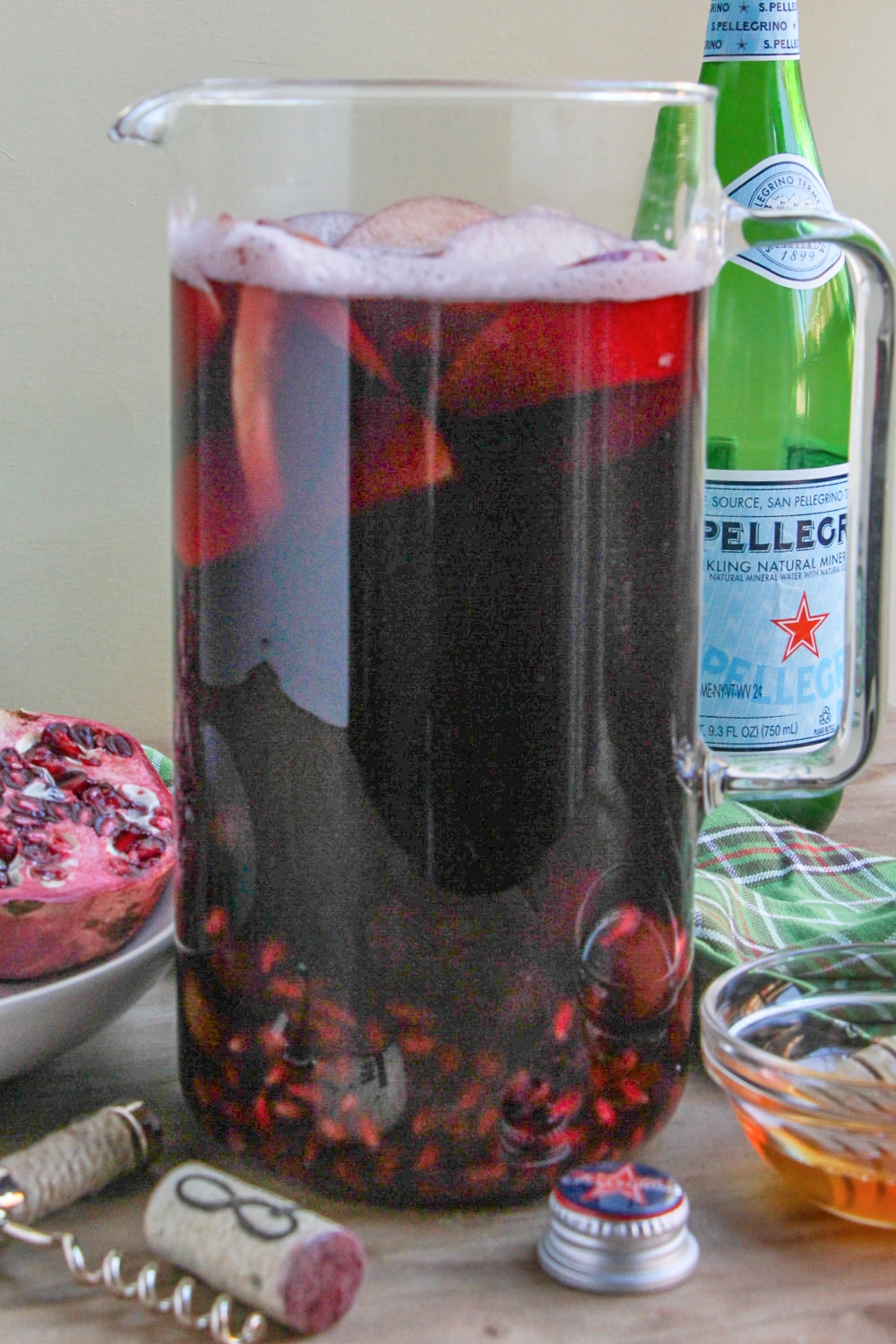 A tall pitcher of sangria on a wood tabletop.