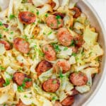 Fried cabbage and kielbasa sausage in a serving bowl.