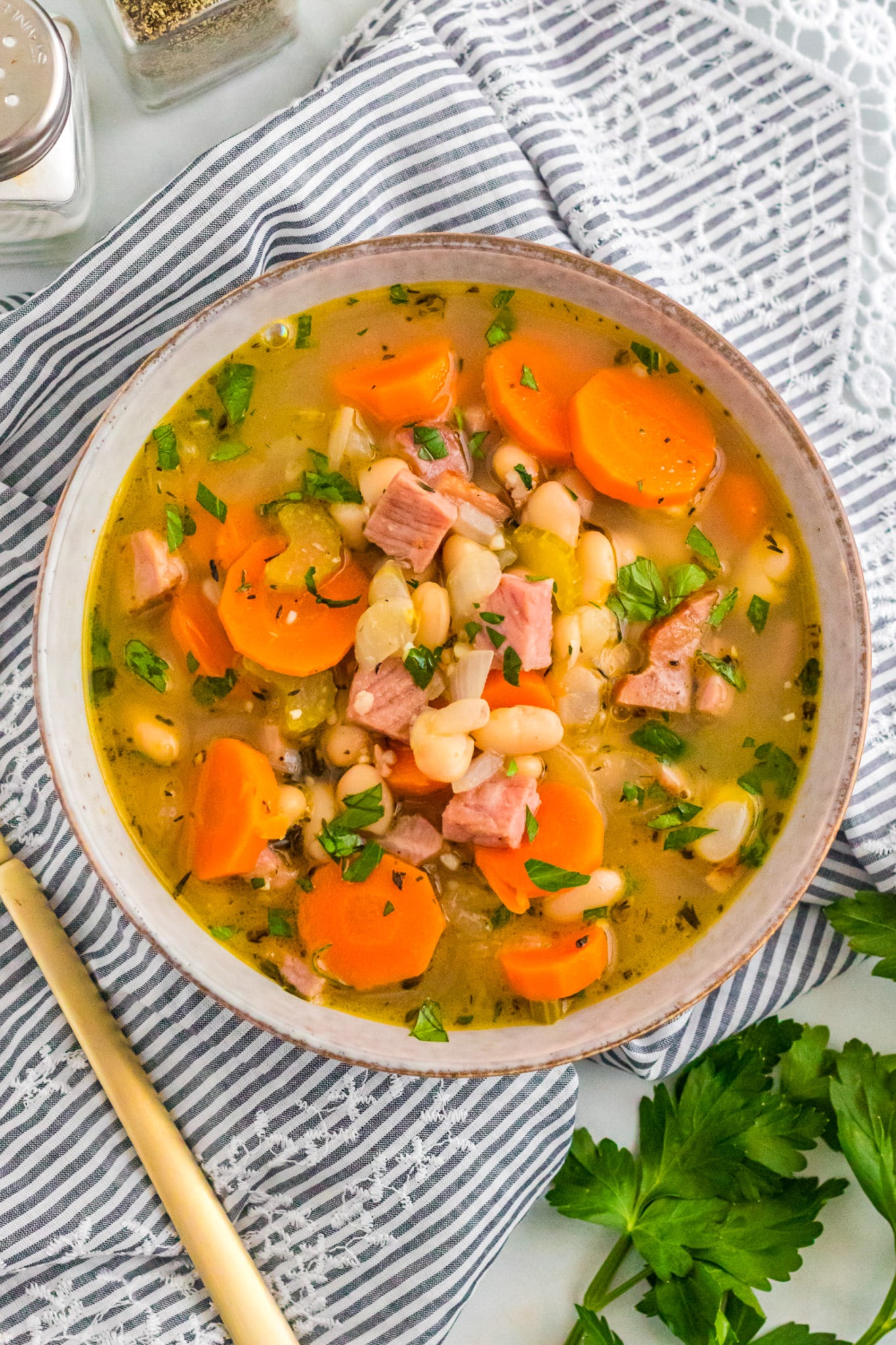 A white bowl filled with Ham and Bean Soup.