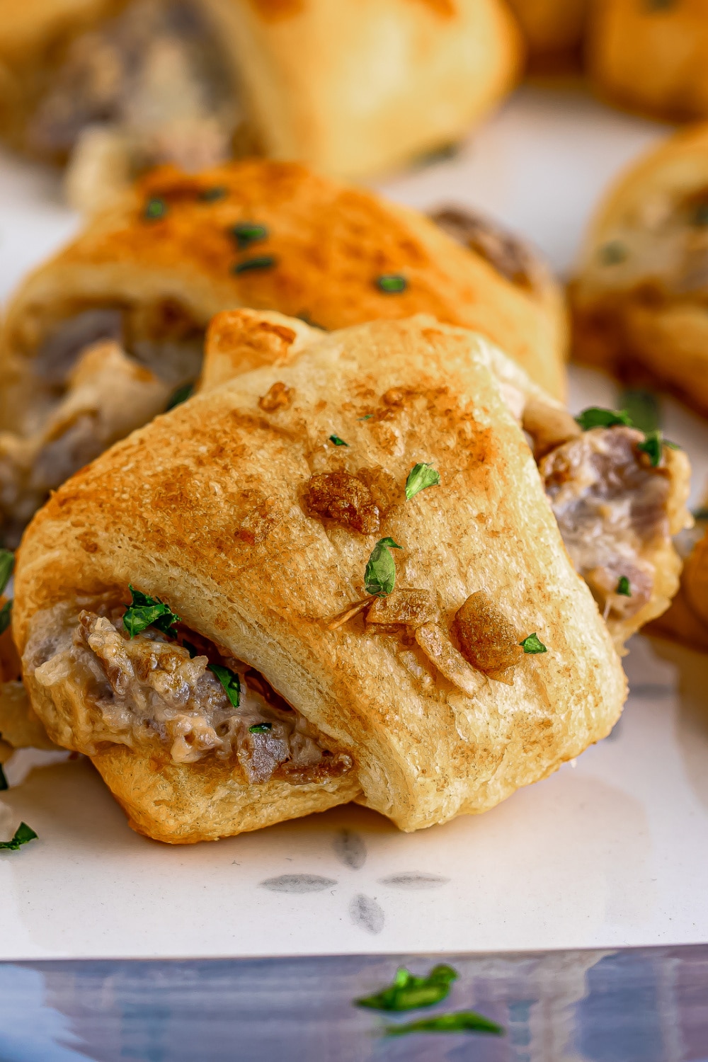 French Dip Crescent Rolls on white parchment paper.