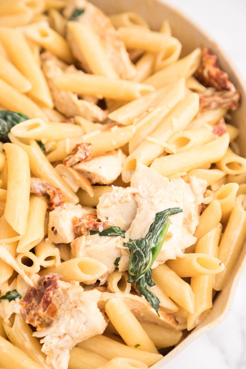 Tuscan Chicken Pasta in a white pan.