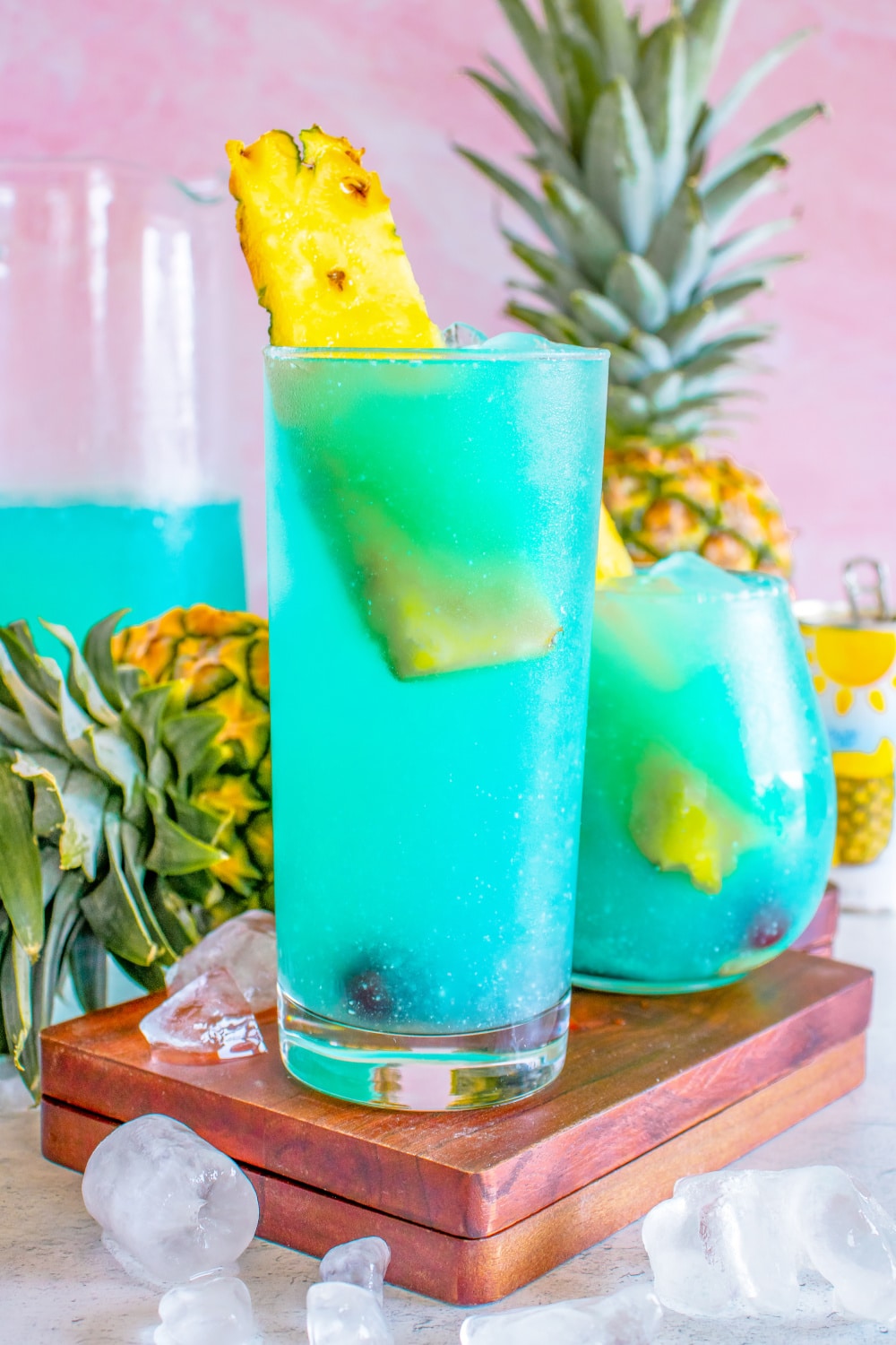 A Blue Hawaiian poured into a glass with ice and pineapple.