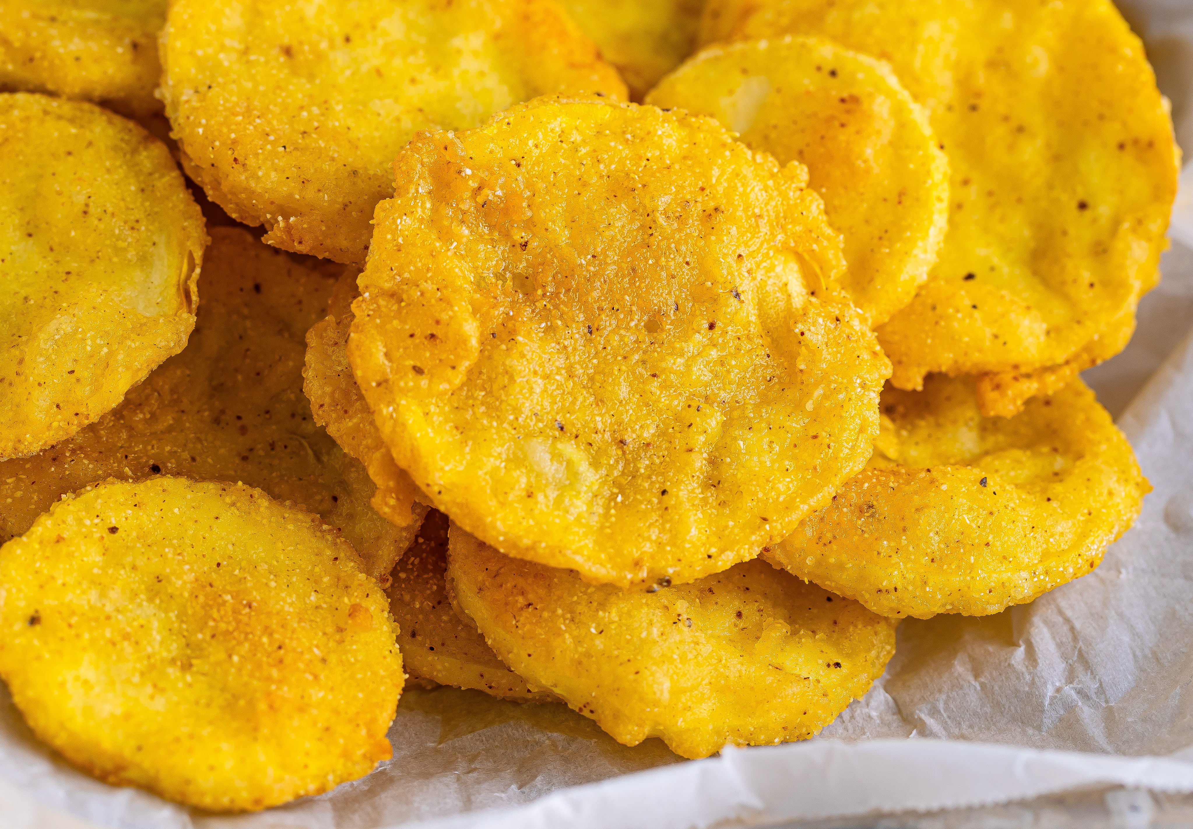 Slices of fried squash piled on a platter.