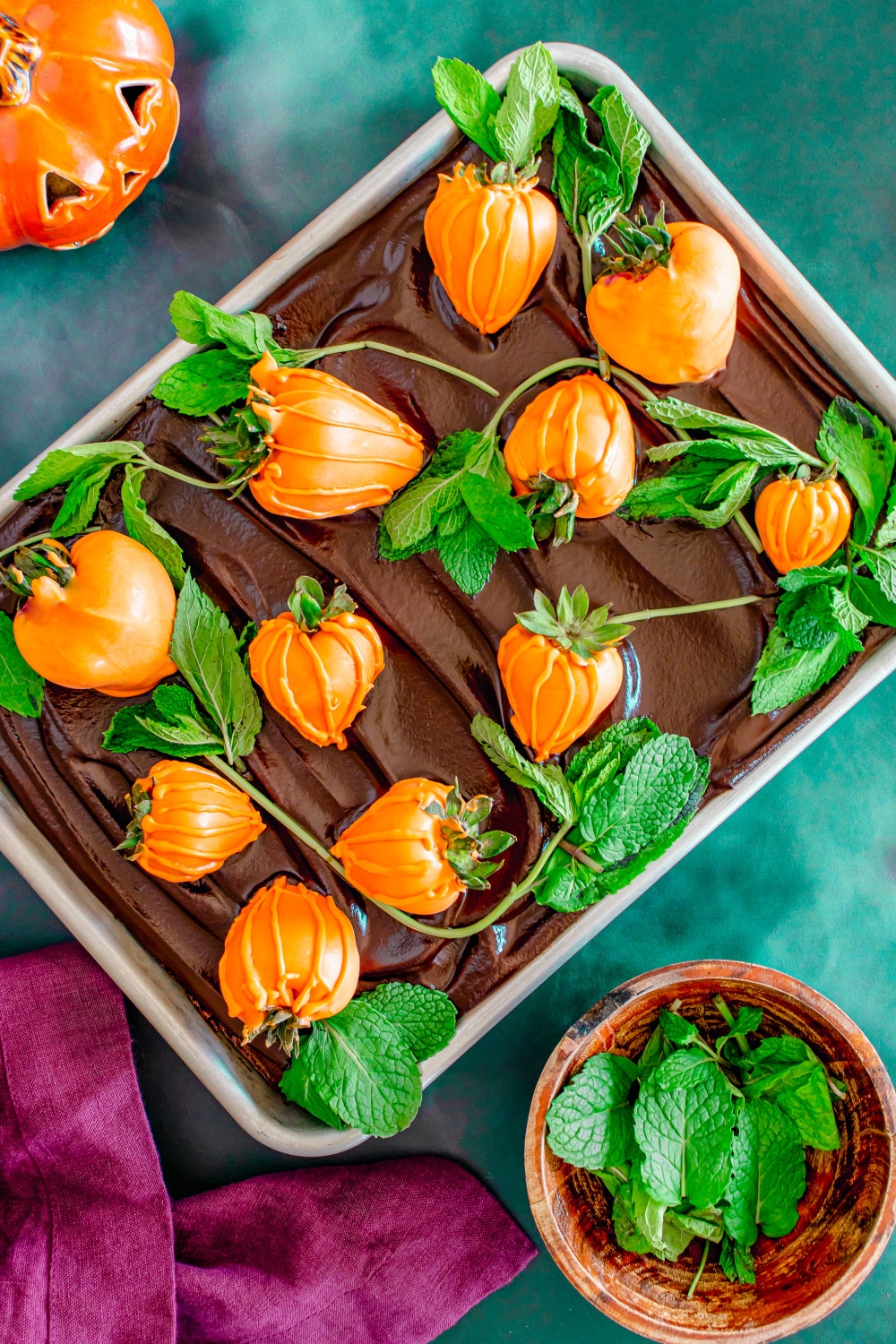 Chocolate brownies with chocolate ganache and orange candy dipped starwberries make a "pumpkin patch" in a baking pan.