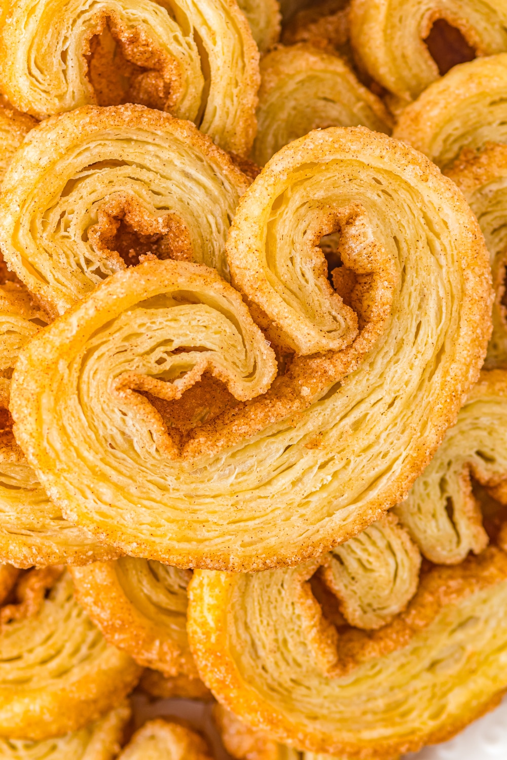 A Palmier sits atop a pile of cookies.