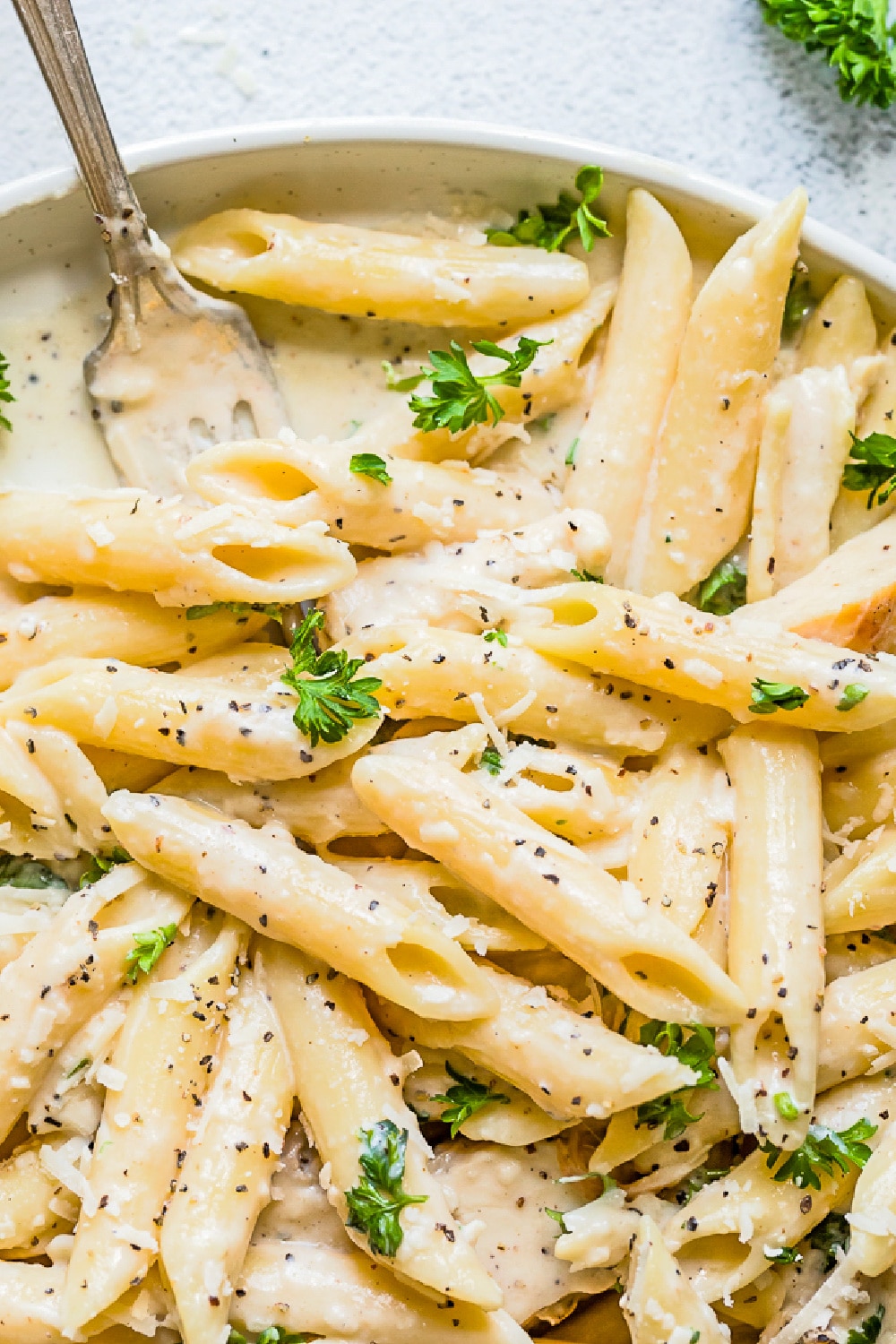 Pasta and chicken in a creamy sauce garnished with parsley. 