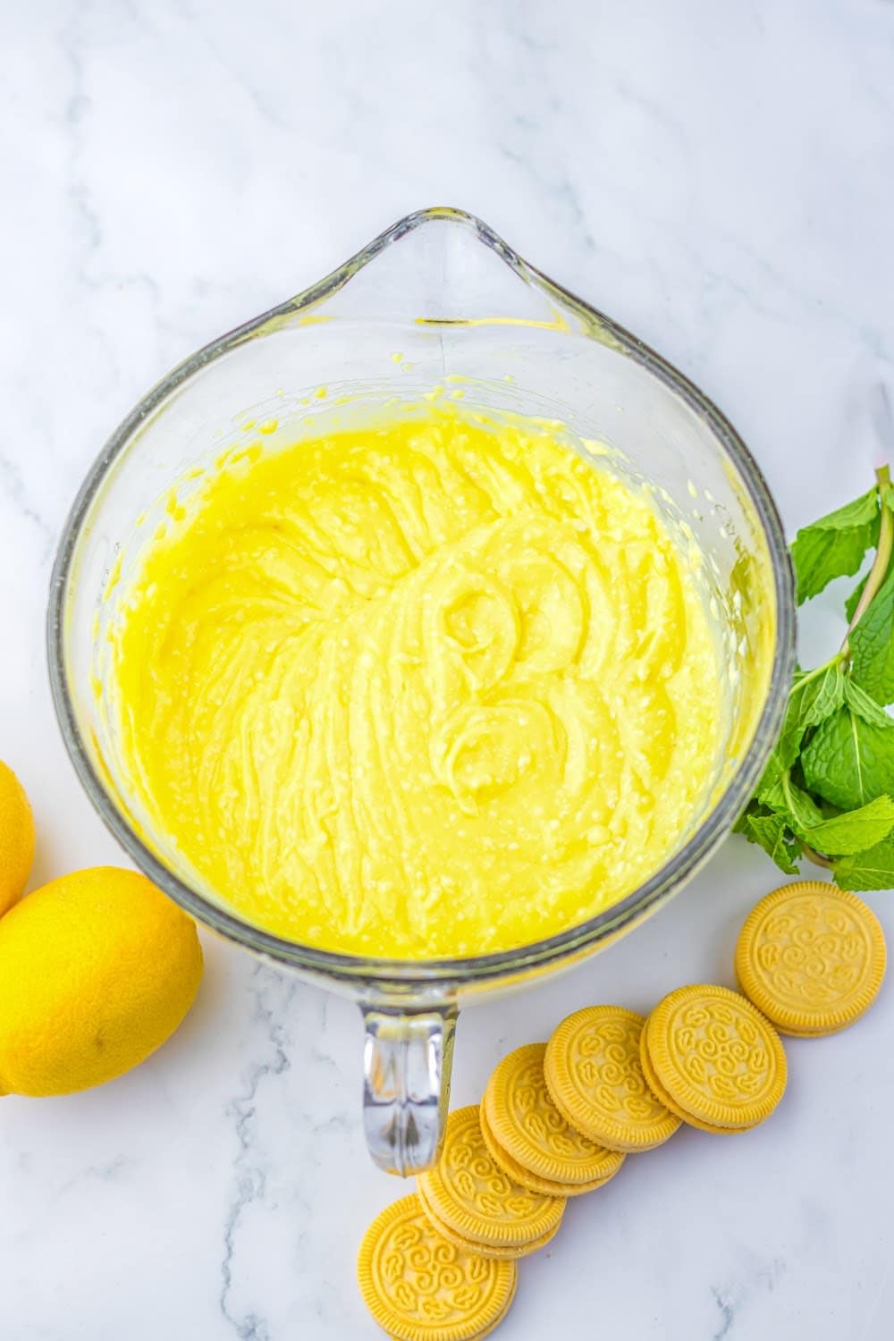 The lemon cream cheese mixture in a clear glass batter bowl.