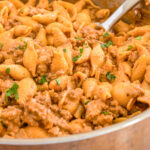 Creamy Beef and Shells in a large skillet with a serving spoon.