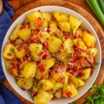 German Potato Salad with bacon and onions served in a white bowl.