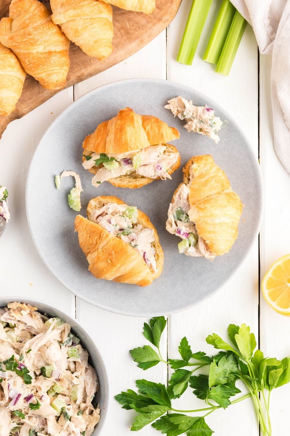 Chicken salad sandwiches on croissants on a white plate.