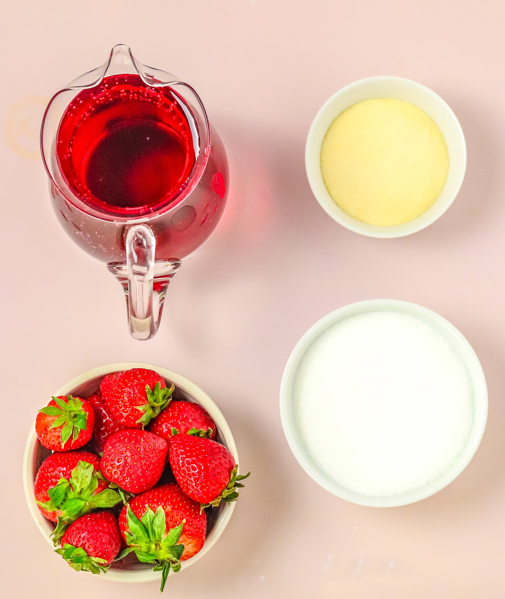 Measured Ingredients needed to make Strawberry Jello mold on a pink tablecloths.
